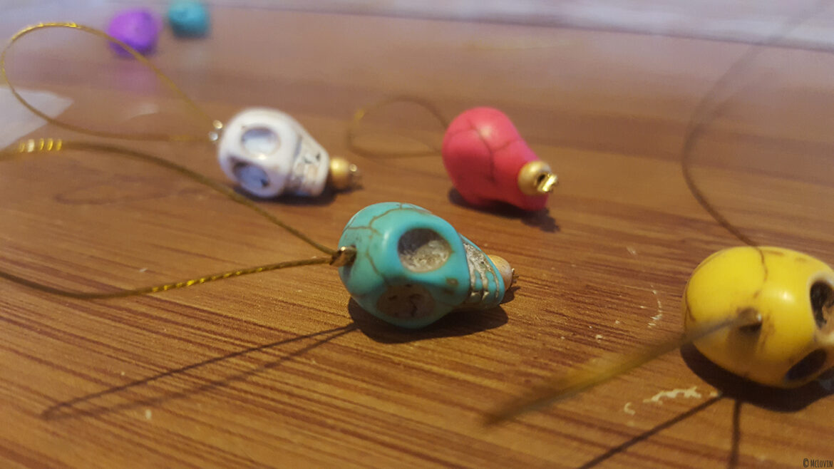 Les anneaux marqueurs pour tricot "Día de muertos" de toutes les couleurs que j'ai fabriqués toute seule en vrac sur la table ! DIY