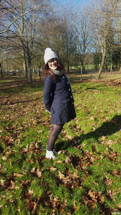 Moi debout dans mon jardin avec mon bonnet Chic de Phildar tricoté sur la tête.