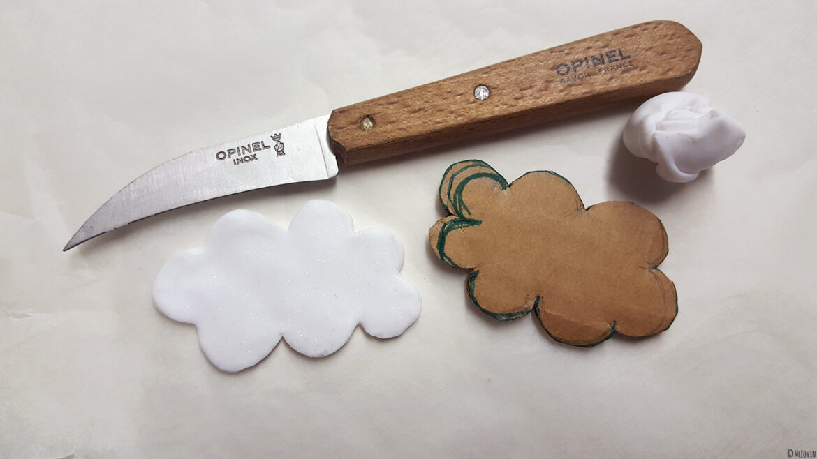 La forme de nuage en pâte polymère découpée pour servir de base à la broche nuage en fausse chantilly.