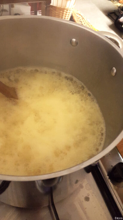 L'infusion de fleurs jaunes et comestibles de coucou ou primevère officinale filtrée et mélangée au sucre gélifiant et à l'agar-agar en ébullition pour la préparation de la gelée.