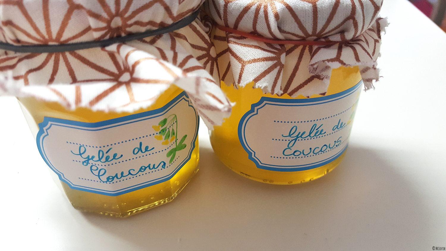 La gelée de fleurs jaunes et comestibles de coucou ou primevère officinale en pots avec étiquettes et cache-pots en chutes de tissus.
