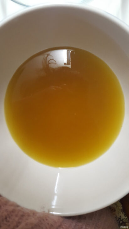 L'infusion de fleurs jaunes et comestibles de coucou ou primevère officinale filtrée, prête pour la préparation de la gelée.