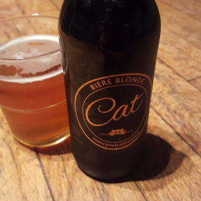La bouteille de bière blonde artisanale Cat et son super logo doré représentant un chat à côté d'un verre servi.
