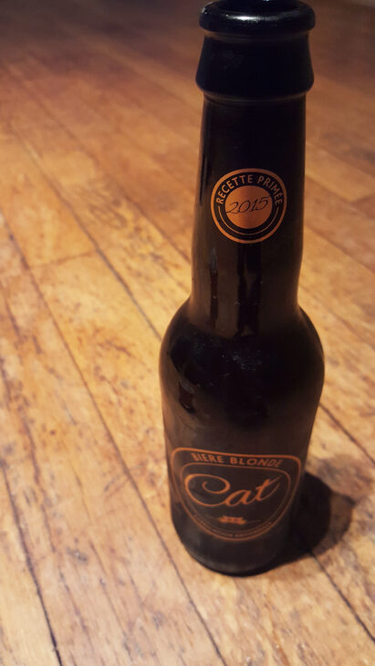 La bouteille de bière blonde artisanale Cat, dont la recette a été primée en 2015, et son super logo doré représentant un chat à côté.