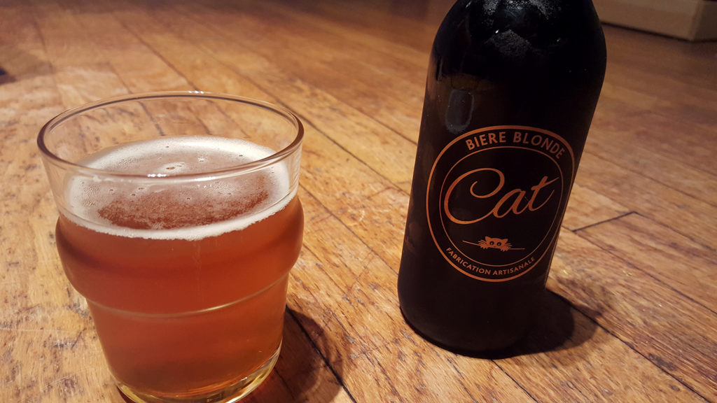 La bouteille de bière blonde artisanale Cat et son super logo doré représentant un chat à côté d'un verre servi.