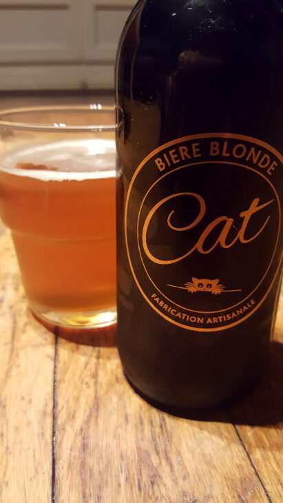 La bouteille de bière blonde artisanale Cat et son super logo doré représentant un chat à côté d'un verre servi.