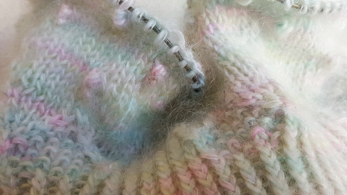 Gros plan sur le bonnet à noppes et côtes torses Kobuk de la créatrice Caitlin Hunter de Boyland Knitworks en cours de tricot à la main sur aiguilles circulaires par McLovin.