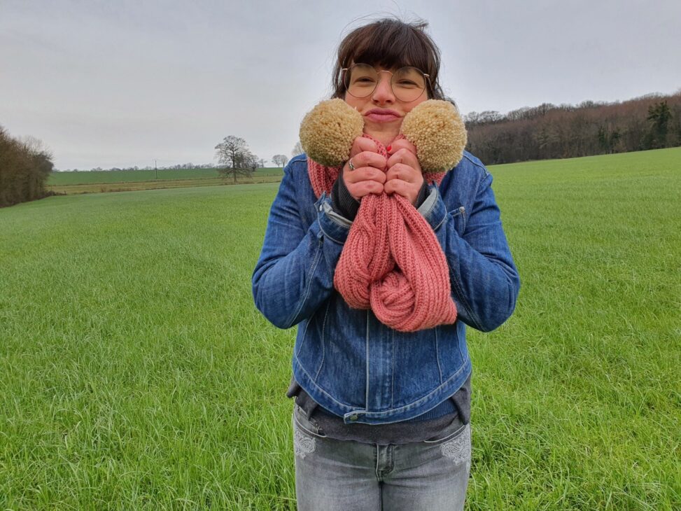 Ma grosse écharpe vieux rose avec ses énormes pompons crème tricotée main avec une torsade de côtes anglaises de face.