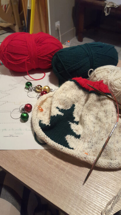 Un gilet de Noël tricoté main en cours de réalisation avec un patron jacquard.